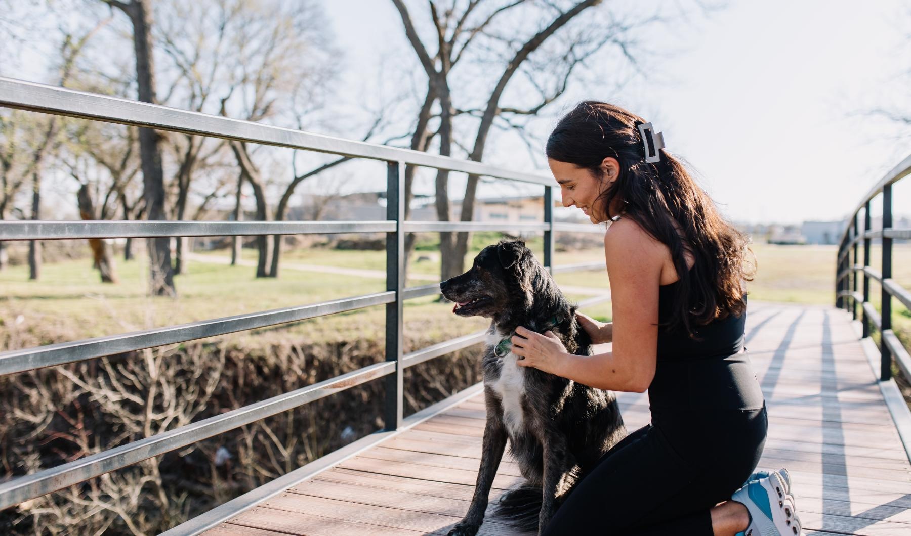 We welcome your pet family a woman sitting on a bench with a dog
