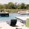 a deck with chairs and a table by a pool