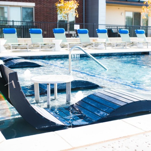 Resort-style swimming pool a pool with chairs around it