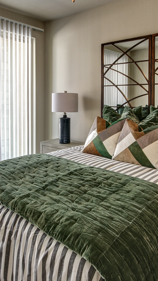 a bedroom with a green and white bedspread at The Gates at Meadow Place