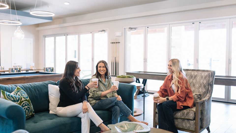 three women sitting on couches in a living room at The Gates at Meadow Place