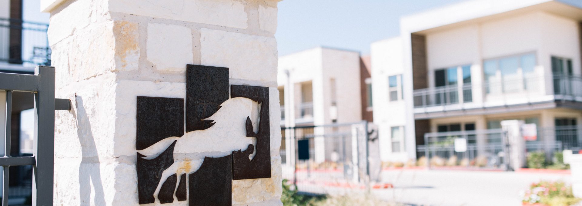 a horse statue on a sign in front of a building at The Gates at Meadow Place